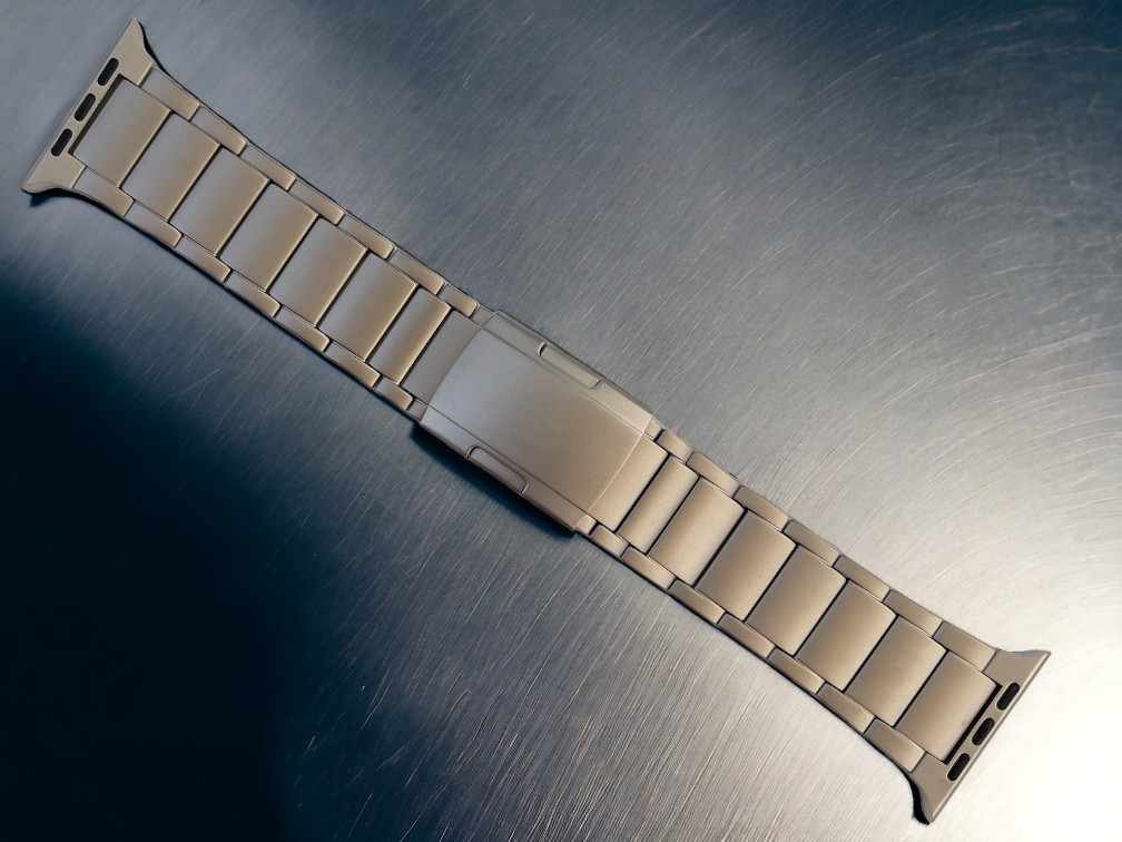 anhem titanium apple watch band in titanium color laid flat on metal surface