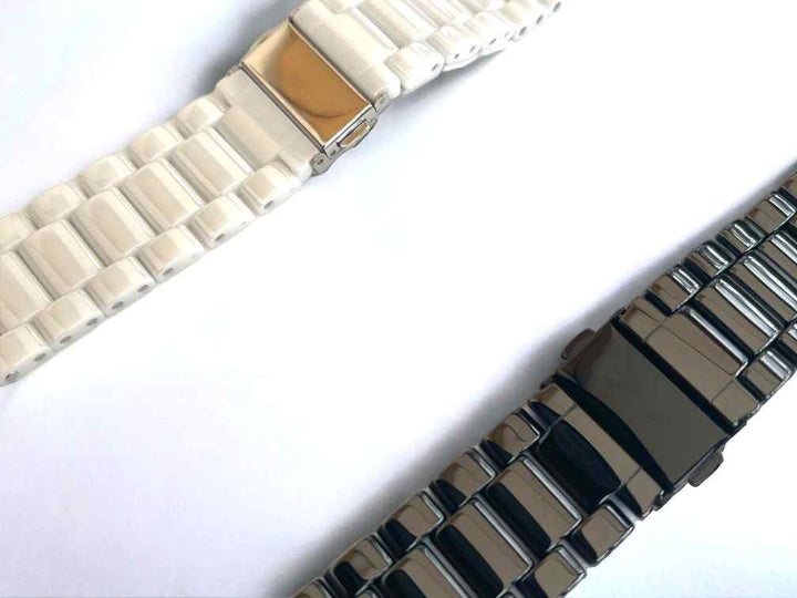 Close-up of a black and a white Classic Ceramic Band by Anhem, highlighting their elegant finish and secure clasp. Enhance your Apple Watch experience with these Ceramic Apple Watch Bands.
