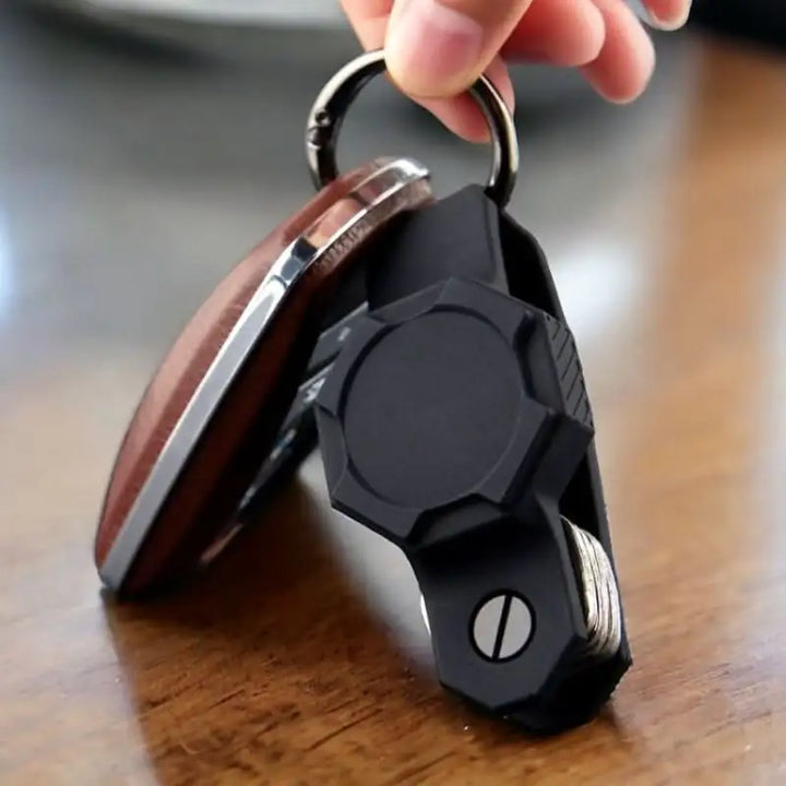 Anhem's Smart Key Case Holder & Organizer for Tag on a wooden table, emphasizing usability with a keychain and an AirTag, functioning as an essential AirTag Keychain Holder.  Smart Key Case Holder & Organizer for Tag  anhem.myshopify.com