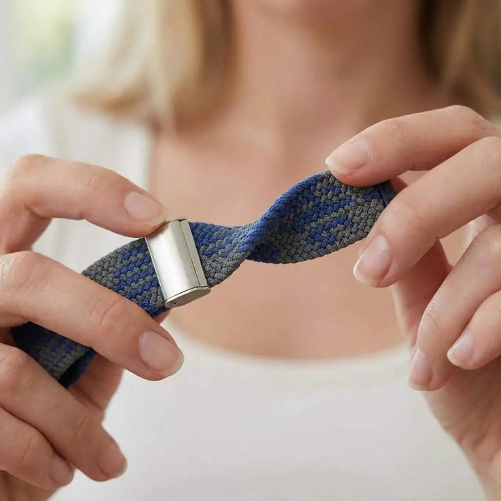 Anhem braided nylon Apple Watch band in blue and grey with a metallic connector held by hands