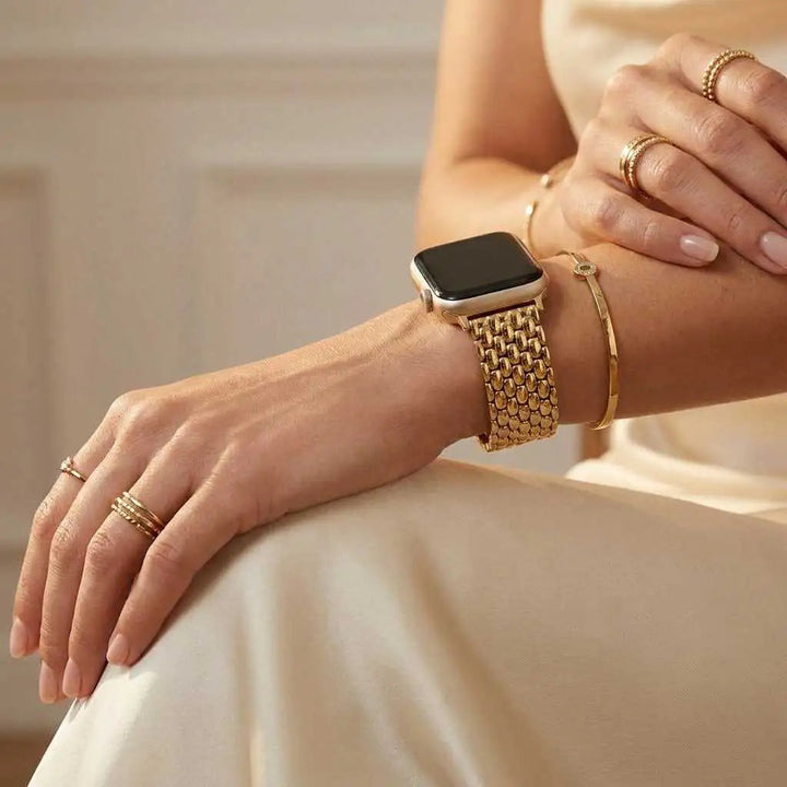 Anhem Opulent Steel Strap in gold on a woman's wrist, featuring a polished metal link design for Apple Watch.
