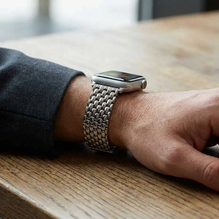 Anhem Opulent Steel Strap, a silver stainless steel link band on an Apple Watch worn on a man's wrist.