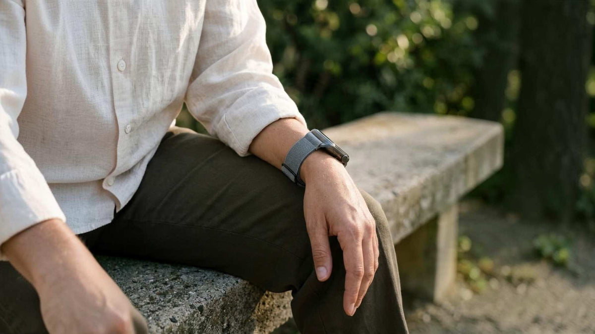 man wearing anhem stretchy apple watch band in blue gray on bench
